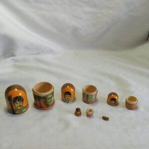 Russian dolls depicting The Beatles and a tiny guitar, hand-painted by a Russian